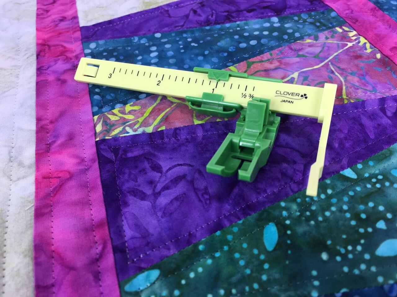 The Ultimate Quilt ‘n Stitch Presser Foot by Nancy Zieman Productions, LLC for Clover available at ShopNZP.com